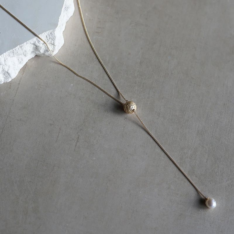 Tutti & Co Tidal Necklace Gold NE692G on stone