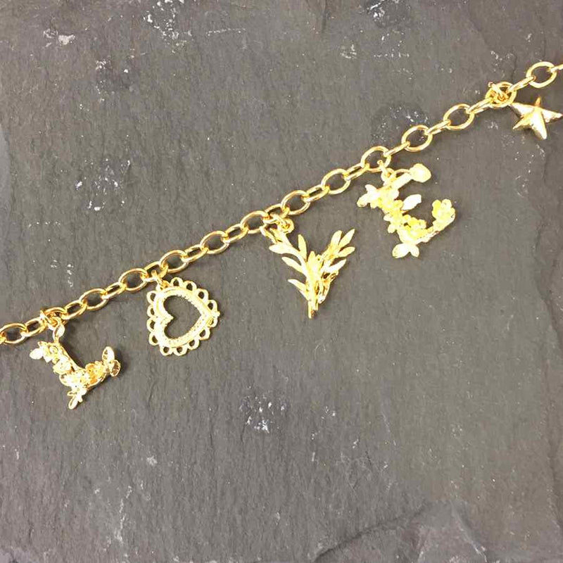 Alex Monroe Jewellery Love Mixed Charm Bracelet Gold Plate on slate