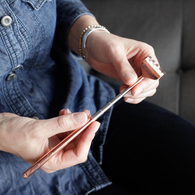 Copper Extendable Back Scratcher in model's hands