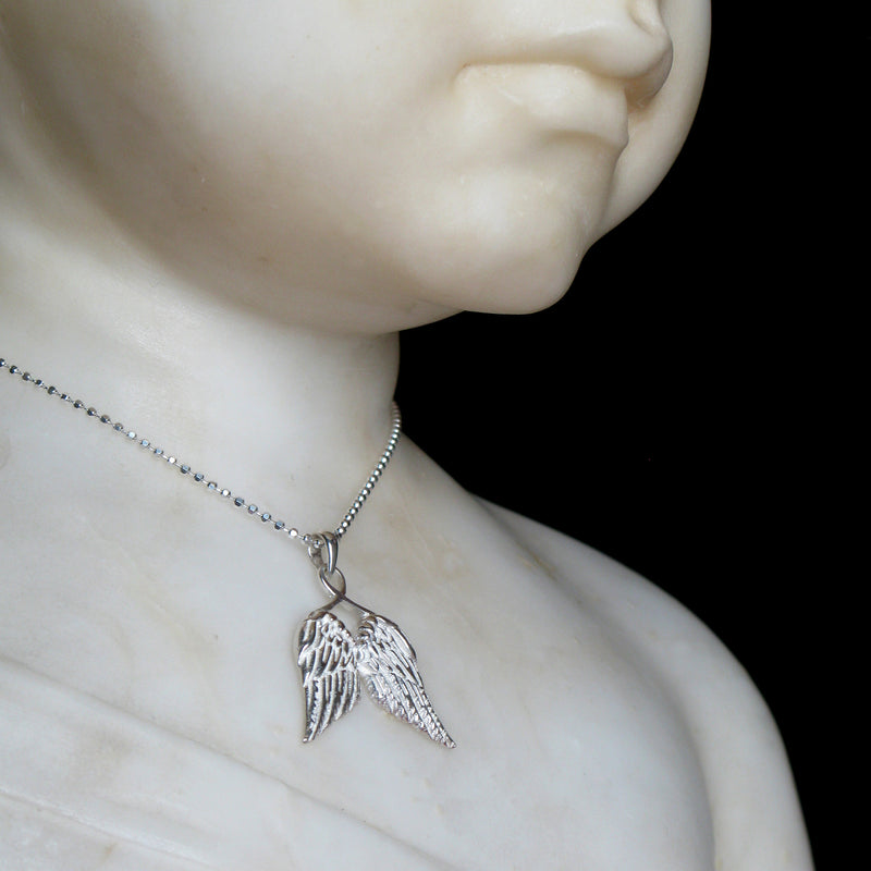Guardian Angel Wings Necklace on statue