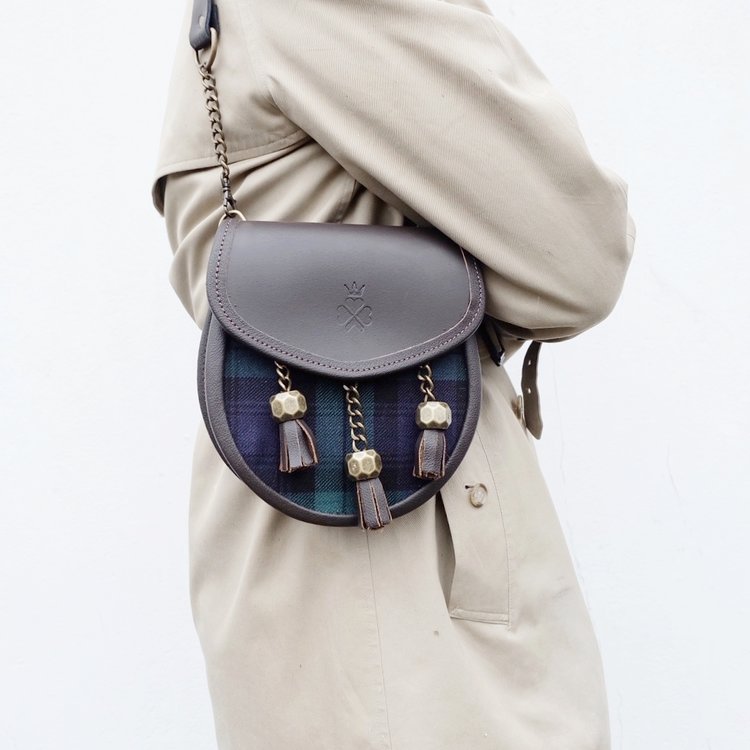 Nixey Blackwatch Sporran Handbag in Brown Leather with Bronze Fittings on model as shoulder bag
