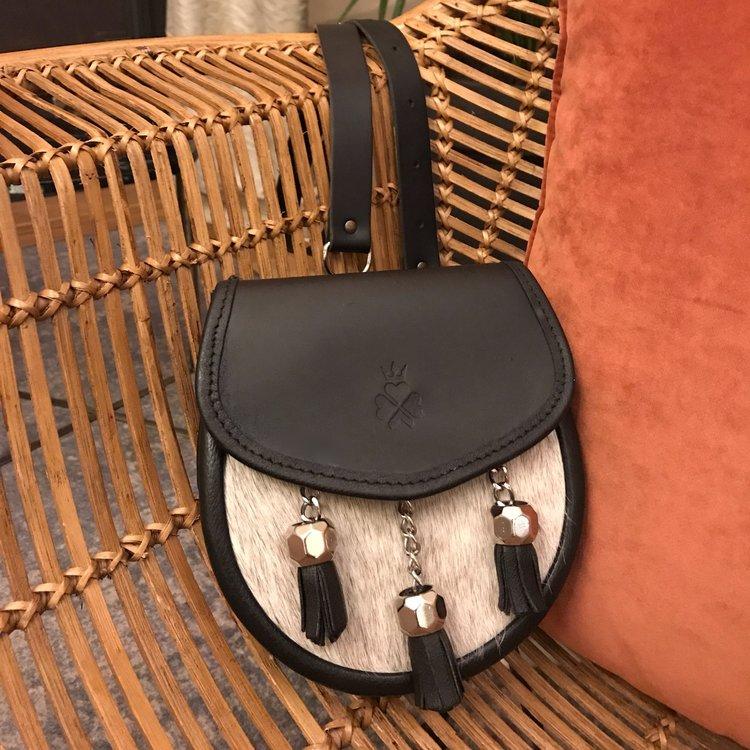 Nixey Sporran Handbag in Light Hair-on Hide in Black with Chrome Fittings on chair