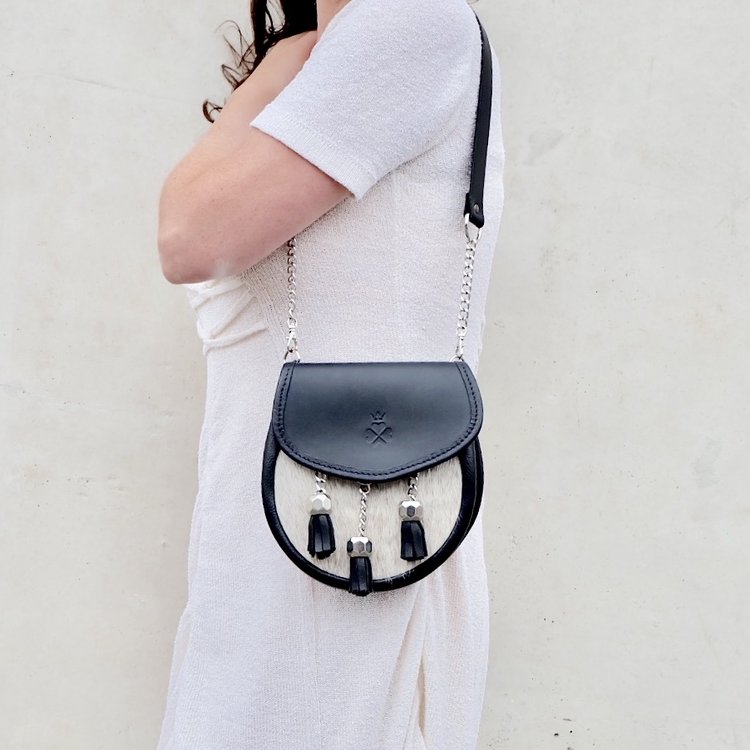 Nixey Sporran Handbag in Light Hair-on Hide in Black with Chrome Fittings on model as shoulder bag